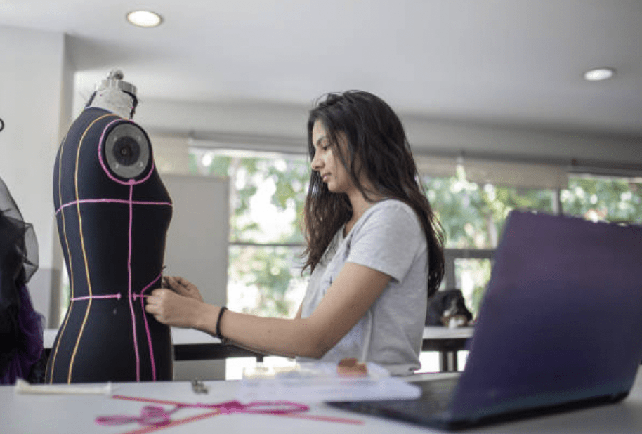 Formazione sartoriale. Giovane donna lavora con manichino.
